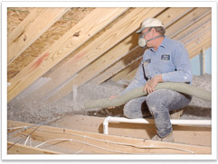 Blown-in fiberglass insulation being installed in an attic