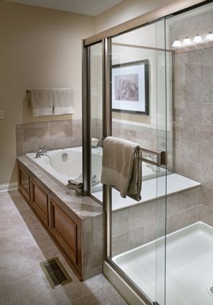 Glass shower door installation in a remodeled bathroom with separate tub.