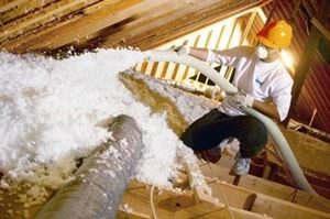 Blown fiberglass insulation being installed in an attic.