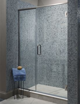 Frameless glass shower door enclosing shower with small blue tiles on surrounding walls.