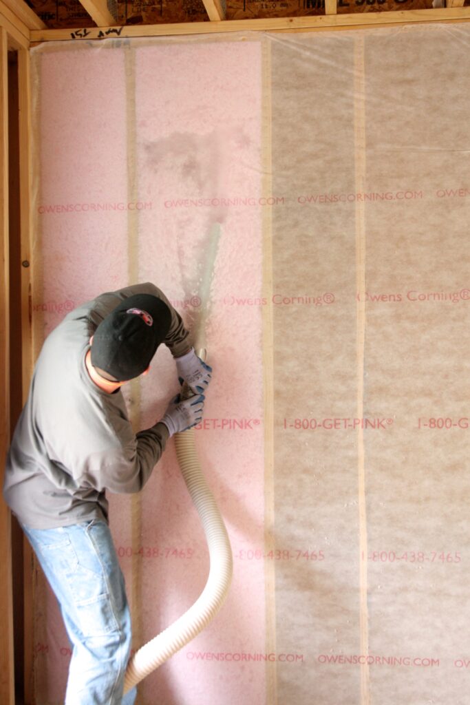 Insulation contractor installing blown insulation